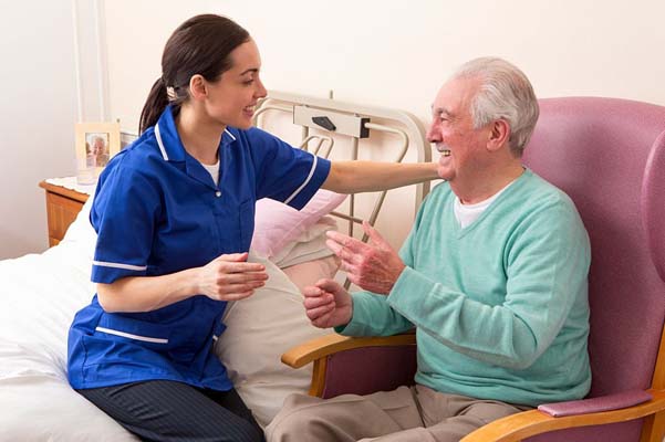 Nurse in a hospital ward with a senior male patient doing an examination