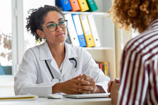 Female patient speaking with her paediatrician in a doctors office